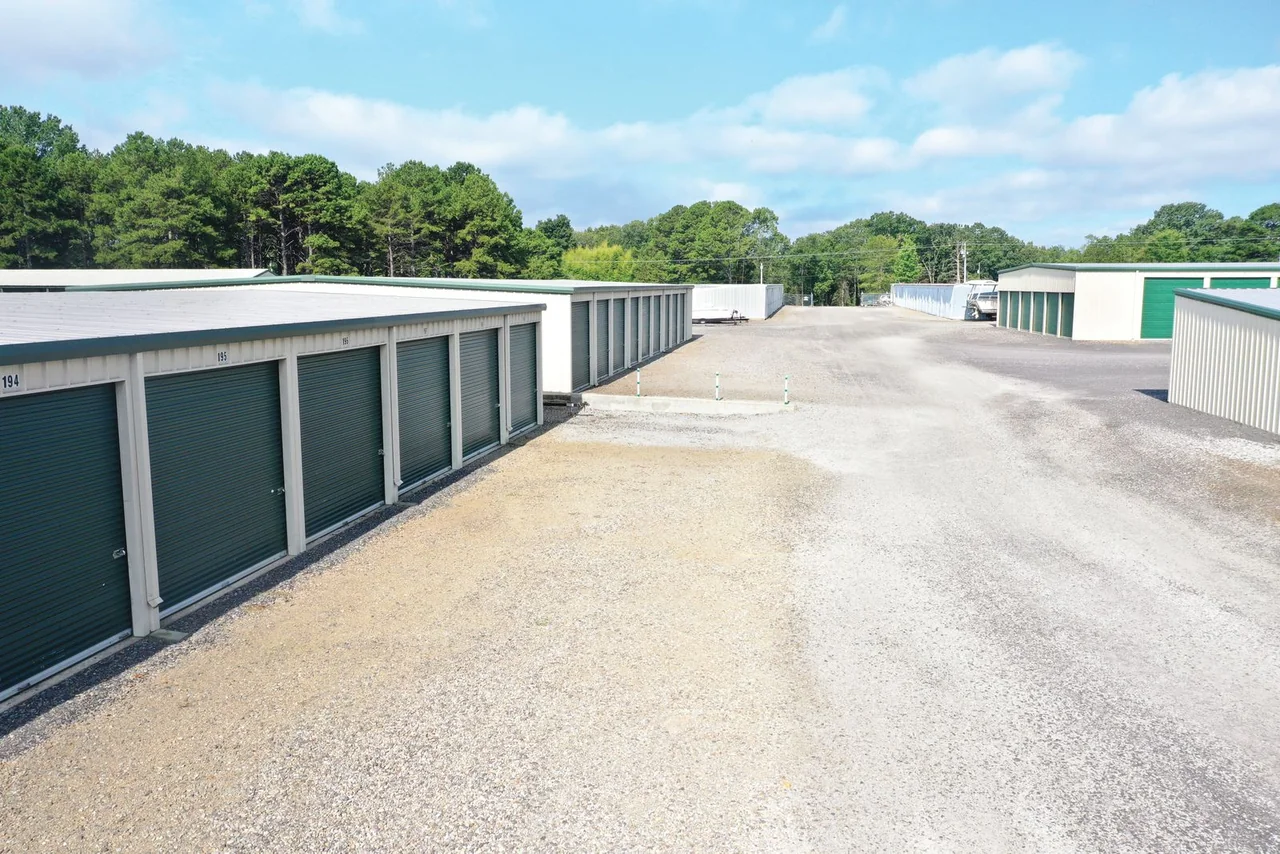 Drive-up storage unit aisle with green roll-up doors at Golden Anchor Storage